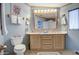 Bathroom with toilet, sink with vanity and large mirror, light blue walls and tile floors at 5524 E Harmon Cir, Mesa, AZ 85215