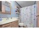 Bright bathroom featuring a vanity, toilet, and stylish floral shower curtain at 5524 E Harmon Cir, Mesa, AZ 85215