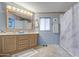 Full bathroom featuring light blue walls, sink with vanity and large mirror, and shower and tub combo at 5524 E Harmon Cir, Mesa, AZ 85215