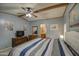 Bedroom with light blue walls, carpeted floors, wood trim, TV on bureau and view into bathroom at 5524 E Harmon Cir, Mesa, AZ 85215