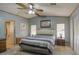 Bedroom with a ceiling fan, carpeted floors, blue walls, and two windows and blue, white, and gray bedding at 5524 E Harmon Cir, Mesa, AZ 85215