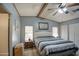 Bedroom with a ceiling fan, carpeted floors, blue walls, and two windows and blue, white, and gray bedding at 5524 E Harmon Cir, Mesa, AZ 85215