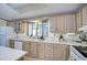Bright kitchen with laminate countertops, wood cabinets, and updated appliances at 5524 E Harmon Cir, Mesa, AZ 85215