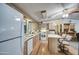 A view of the kitchen area with hardwood flooring, light wood cabinets, white appliances and island with chairs at 5524 E Harmon Cir, Mesa, AZ 85215
