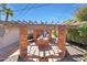 Charming backyard with a brick seating area, grill, pergola, and string lights for outdoor entertainment and relaxation at 6320 N 4Th Pl, Phoenix, AZ 85012