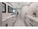 Modern bathroom with double vanity, white marble floors, and a glass-enclosed shower at 6320 N 4Th Pl, Phoenix, AZ 85012