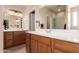 Well-lit bathroom with dual vanities, white countertop, and glass-enclosed shower at 6822 W Alta Vista Rd, Laveen, AZ 85339