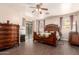 Comfortable bedroom features wood floors, ceiling fan, and closet at 6822 W Alta Vista Rd, Laveen, AZ 85339