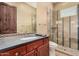Bathroom features a glass shower, wood vanity and a decorative tiled mirror at 7013 E Summit Trail Cir, Mesa, AZ 85207