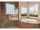 Luxurious bathroom with a soaking tub, separate shower, and elegant fixtures at 7013 E Summit Trail Cir, Mesa, AZ 85207