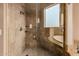 Luxurious walk-in shower and tub area with natural stone tile and built-in shelving at 7013 E Summit Trail Cir, Mesa, AZ 85207