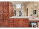 Bathroom featuring custom wood cabinets, vanity, a large mirror, and stylish fixtures at 7013 E Summit Trail Cir, Mesa, AZ 85207