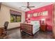 Comfortable bedroom with a striking red accent wall and wood-look flooring at 7013 E Summit Trail Cir, Mesa, AZ 85207
