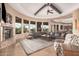 Open living room features a fireplace, large windows, a ceiling fan, and comfortable seating at 7013 E Summit Trail Cir, Mesa, AZ 85207