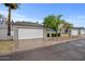 Single-car garage with white door and mature tree in front of a single-story home at 7027 S 41St St, Phoenix, AZ 85042