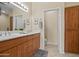Bright bathroom with dual sinks, wooden cabinets and tile floors at 705 W Queen Creek Rd # 1201, Chandler, AZ 85248
