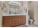 Bathroom with wooden cabinets, dual sinks, and decorative mirror at 705 W Queen Creek Rd # 1201, Chandler, AZ 85248