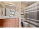 An ample bathroom featuring a wood vanity, toilet, and shower with a striped curtain at 705 W Queen Creek Rd # 1201, Chandler, AZ 85248