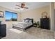 Comfortable bedroom featuring a ceiling fan, dresser, and large window providing natural light and outdoor views at 705 W Queen Creek Rd # 1201, Chandler, AZ 85248