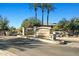 Welcoming community entrance sign with lush landscaping and mature palm trees on a sunny day at 705 W Queen Creek Rd # 1201, Chandler, AZ 85248