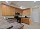 Well-lit kitchen with wood cabinetry, modern appliances, and durable countertops for meal preparation at 705 W Queen Creek Rd # 1201, Chandler, AZ 85248