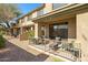 An outdoor patio, featuring a table with chairs, with a view of the desert landscape surrounding the building at 705 W Queen Creek Rd # 1201, Chandler, AZ 85248