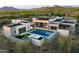 Stunning aerial view of a modern home featuring a sleek pool, spa, and inviting outdoor spaces amidst a lush desert landscape at 7498 E Whisper Rock Trl, Scottsdale, AZ 85266