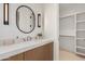 Bathroom featuring updated sink, modern lighting, and walk-in closet at 7498 E Whisper Rock Trl, Scottsdale, AZ 85266