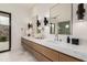 Bathroom featuring double sinks, marble countertops, modern lighting and stone accent wall at 7498 E Whisper Rock Trl, Scottsdale, AZ 85266