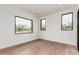 Bright bedroom with hardwood floors and multiple windows framing views of the surrounding landscape at 7498 E Whisper Rock Trl, Scottsdale, AZ 85266