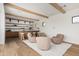 Open living area with a bar, modern furniture, wooden beams, and light hardwood floors at 7498 E Whisper Rock Trl, Scottsdale, AZ 85266