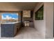 Covered outdoor kitchen featuring a stainless steel grill, counter space, and tile flooring for entertaining at 7498 E Whisper Rock Trl, Scottsdale, AZ 85266