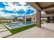 Luxury pool surrounded by artificial turf, tiled walkways, and desert landscaping against a blue sky at 7498 E Whisper Rock Trl, Scottsdale, AZ 85266