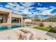 Backyard pool area with a sunken sitting area, artificial turf, desert landscaping, and blue skies at 7498 E Whisper Rock Trl, Scottsdale, AZ 85266