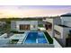 Expansive view of a modern backyard with a sparkling pool, spa, fire pit, and outdoor kitchen against a mountain backdrop at 7498 E Whisper Rock Trl, Scottsdale, AZ 85266