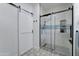 Modern bathroom features a tiled shower with glass door and a stylish barn door to the left at 7822 S 15Th Way, Phoenix, AZ 85042