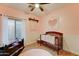 A darling Bedroom with a cozy crib, round rug, and soft pink walls at 7822 S 15Th Way, Phoenix, AZ 85042