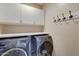 A functional laundry room with side-by-side washer and dryer, and white cabinets at 7822 S 15Th Way, Phoenix, AZ 85042