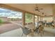 Spacious covered patio with a dining table and multiple ceiling fans overlooking the gravel backyard at 7822 S 15Th Way, Phoenix, AZ 85042