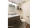 Powder bathroom includes gray vanity with marble counter, wood shelf and simple finishes at 7930 E Arlington Rd # 8, Scottsdale, AZ 85250
