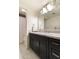 Bright bathroom features a dark vanity with marble countertop and a shower with white curtain at 7930 E Arlington Rd # 8, Scottsdale, AZ 85250