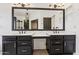 Bathroom with dual sinks, dark cabinets, and a large mirror perfect for getting ready at 7931 W Shaw Butte Dr, Peoria, AZ 85345