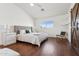 Bright primary bedroom with hardwood floors, a comfortable bed, and a unique barn door accent at 7931 W Shaw Butte Dr, Peoria, AZ 85345