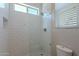 Bathroom featuring a white tile shower and window at 8504 S 30Th St, Phoenix, AZ 85042