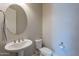 Compact powder room features a pedestal sink, toilet, and round mirror for guests at 8504 S 30Th St, Phoenix, AZ 85042