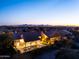 Aerial view of a luxury home with a pool and manicured landscape at twilight at 9238 E Palm Tree Dr, Scottsdale, AZ 85255