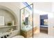 Luxurious bathroom with soaking tub, double vanity, decor niche, and backyard access at 9238 E Palm Tree Dr, Scottsdale, AZ 85255