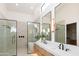 Bright bathroom featuring double vanity, soaking tub, and frameless glass shower at 9238 E Palm Tree Dr, Scottsdale, AZ 85255