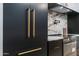 Detail of a kitchen with modern cabinetry, gold hardware, and marble countertops at 9238 E Palm Tree Dr, Scottsdale, AZ 85255