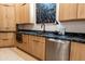 Contemporary kitchen with stainless steel appliances, natural wood cabinets, and black marble countertops at 9238 E Palm Tree Dr, Scottsdale, AZ 85255